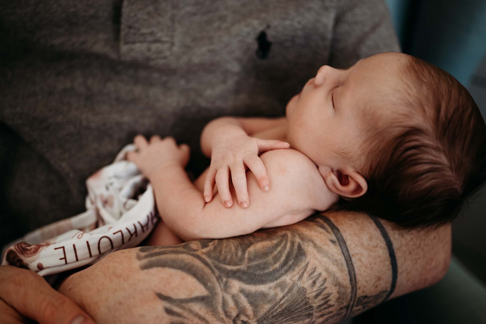 Newborn baby details of hands in dad's arms