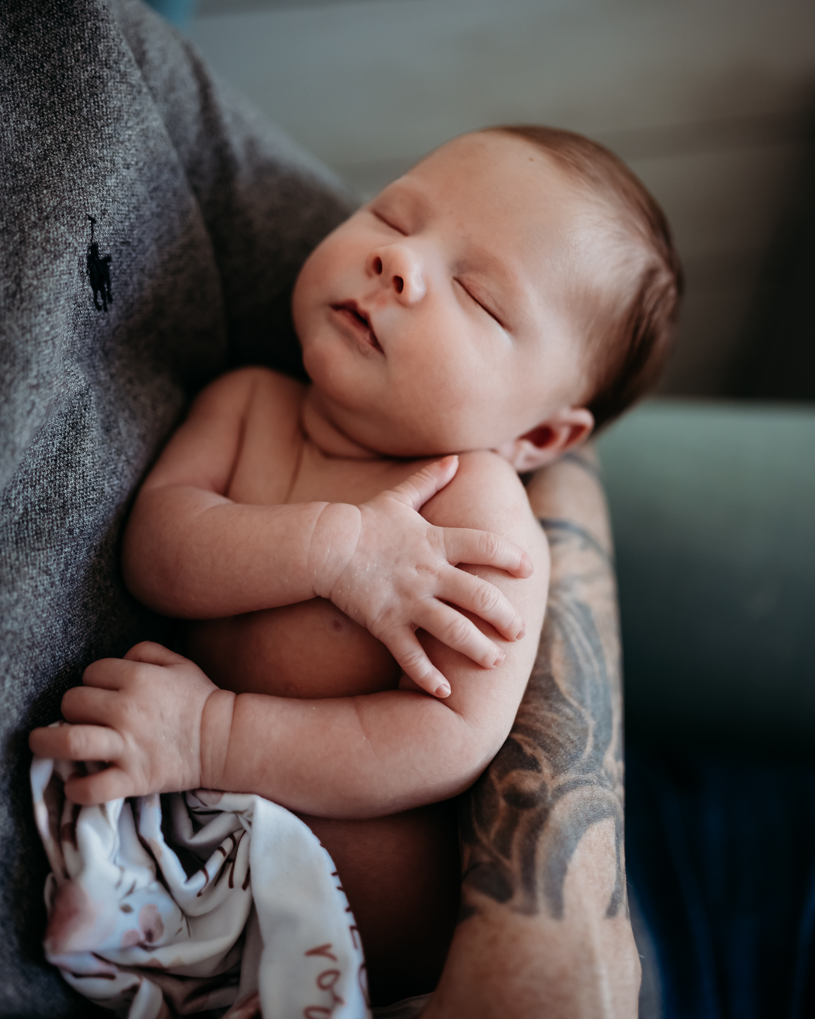dad with tattoos holding his newborn baby